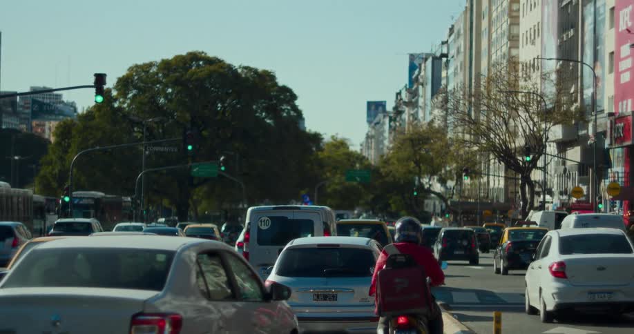 Heavy traffic traveling through a green light in an intersection in the city