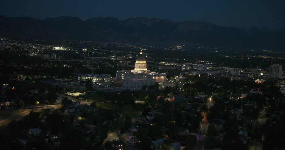Aerial panorama of a metropolis with a white building with a dome in the center and silhouette of mountains on the horizon