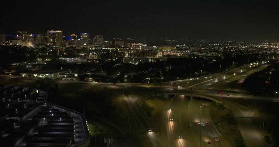 Traffic flows along highways passing the city downtown at night