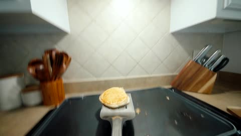 Point of view of a spatula throwing a fried egg