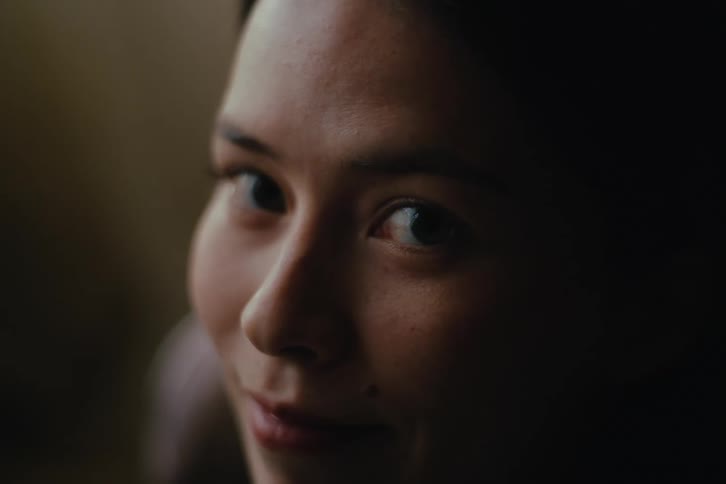 Woman watching television looks over with a smile