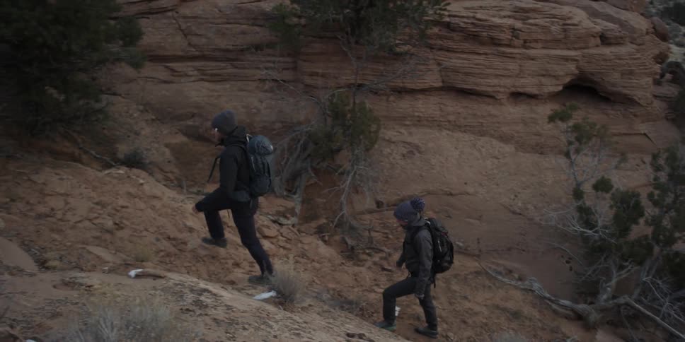 Couple walking up a small incline in the wilderness