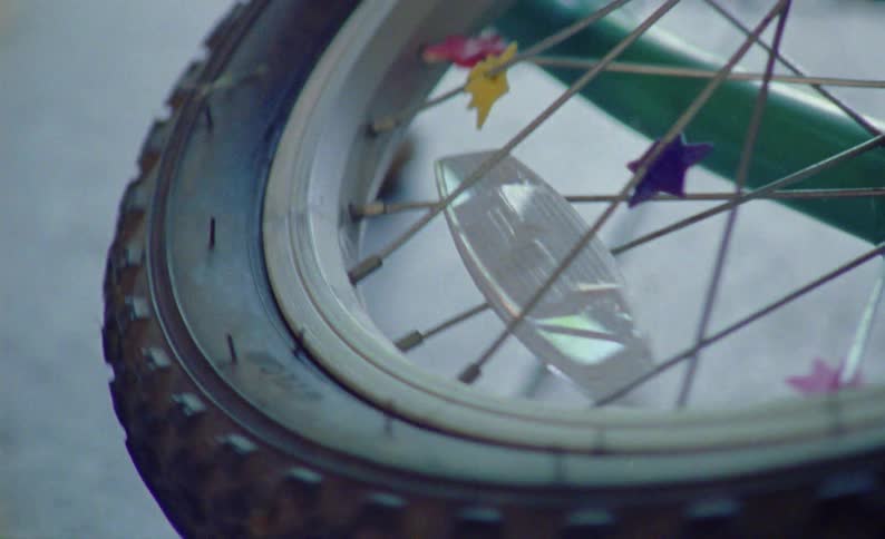Closeup of a bicycle wheel adorned with starshaped decorations on its spokes