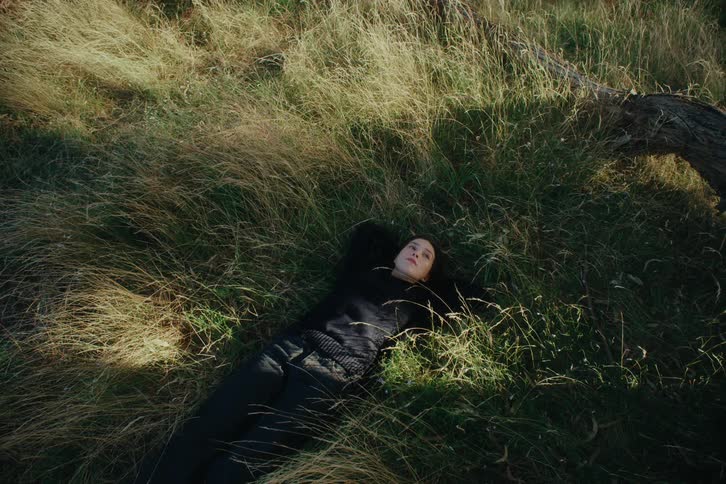Woman lying in grass and a field
