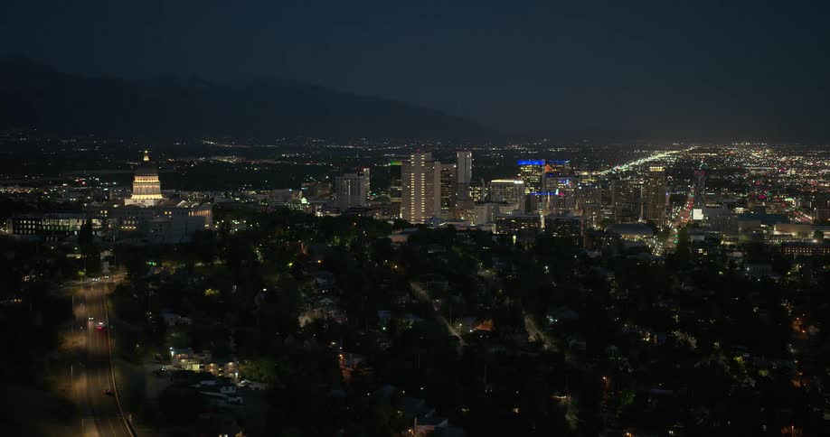 An aerial view of a metropolitan city at night with several building lights on