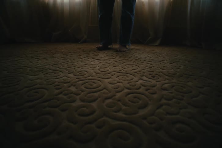 Feet of a person on a rug in a room
