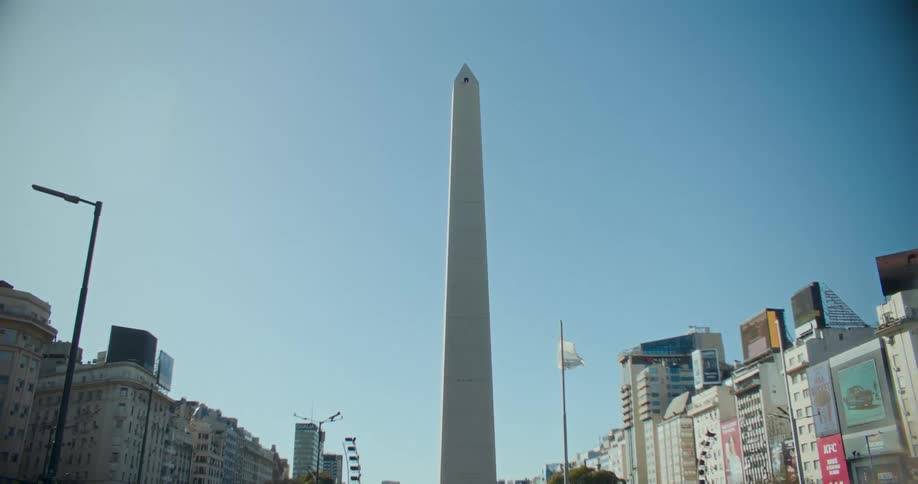 Apartment buildings and other mid rise buildings border an obelisk near downtown during the day