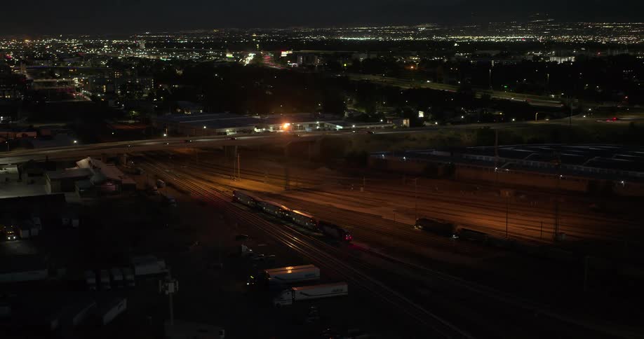 A huge highway with an overpass on top with some cars passing by and its at night