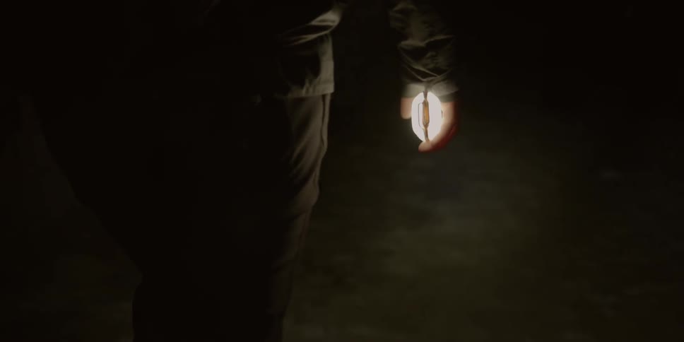 Person walking at night with light in their hand