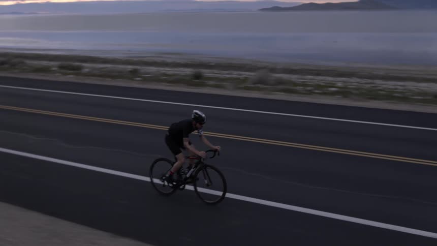 A person is traveling on bicycle down the road on a cloudy day