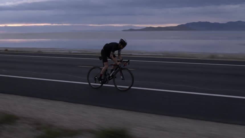 A man bikes down the road