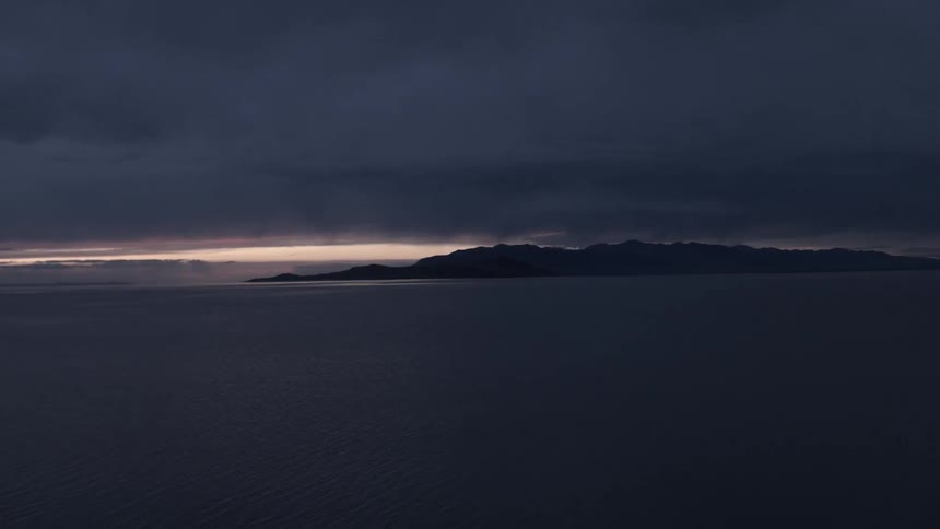 Sunset as seen in the distance through very dark clouds
