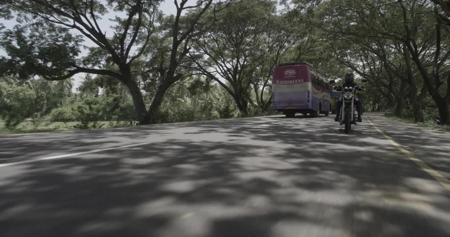 Moving view of two motorcyclists following behind the moving camera on a two lane road