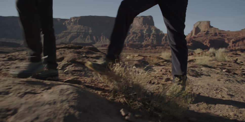 Two men hiking through dry terrain in wilderness