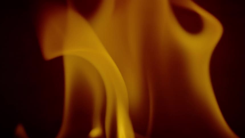Flames of fire coming from a metal sheet in extreme closeup