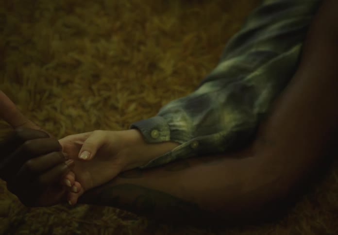 Couple lying on carpet on the floor and holding hands