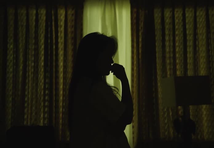 Silhouette of a woman in a dark room