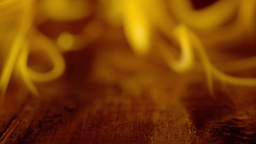 Close up of flames burning over a wooden surface