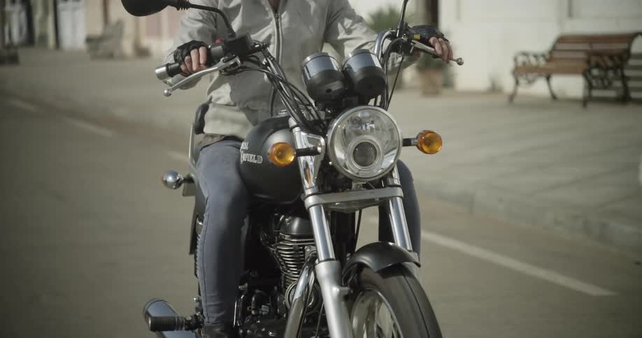 A woman drives a motorcycle on a sunny day