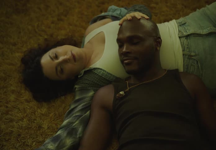 A woman rubs a mans head on the floor