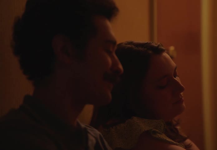 A young couple sitting on the floor of a room talking to each other