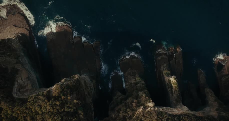Waves crash against the cliff