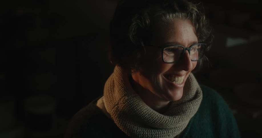Close up of the face of a happy woman wearing glasses and a thick scarf