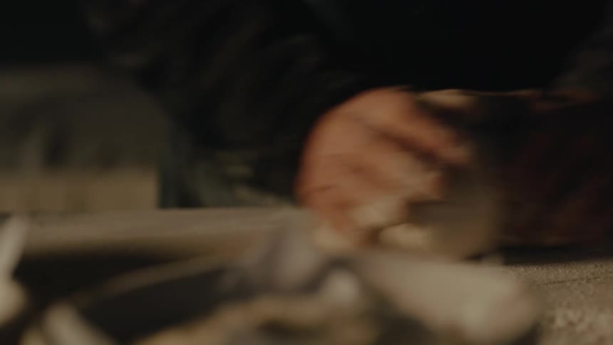 Human hands kneading dough on a wooden table
