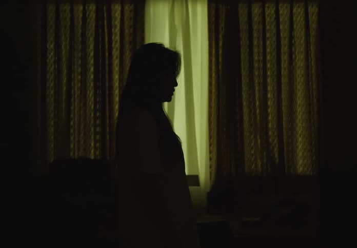 Silhouette of a woman in a dark room