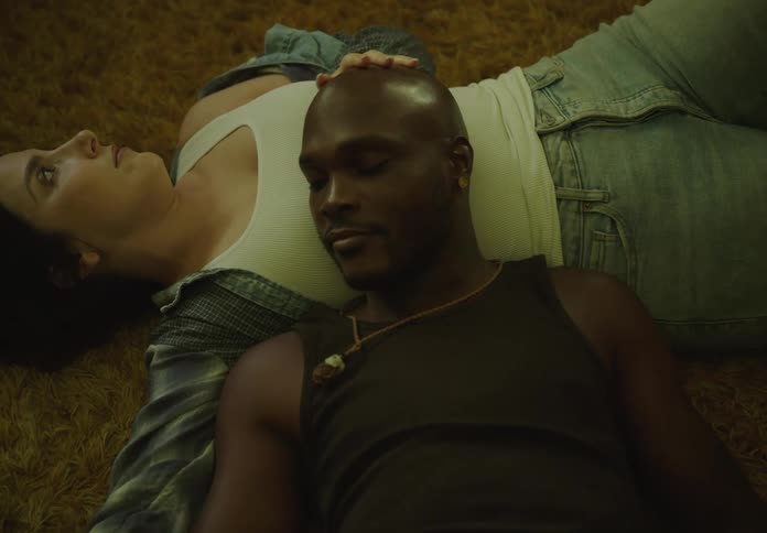 Two people lying on a shaggy carpet one resting their head on the others abdomen