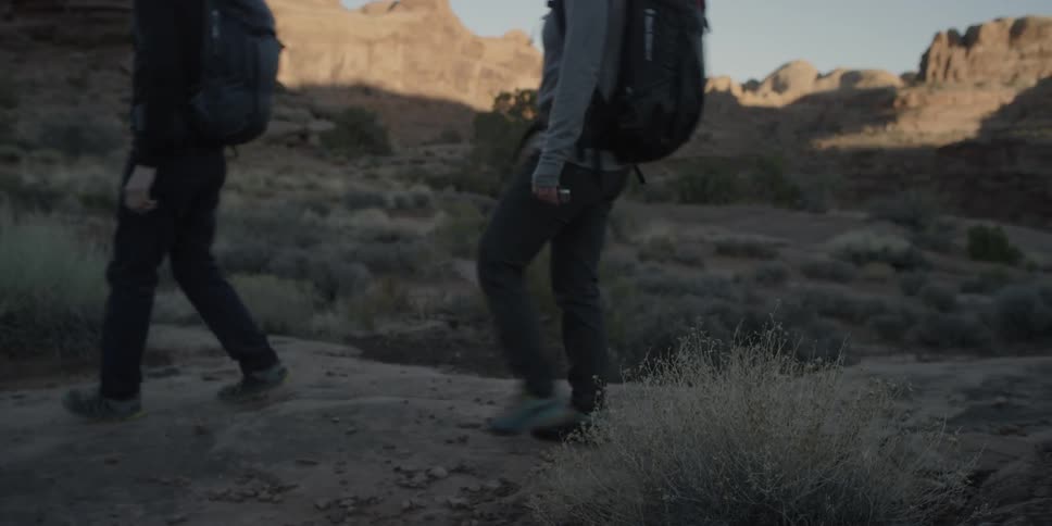 Two people with backpacks hiking in the wilderness