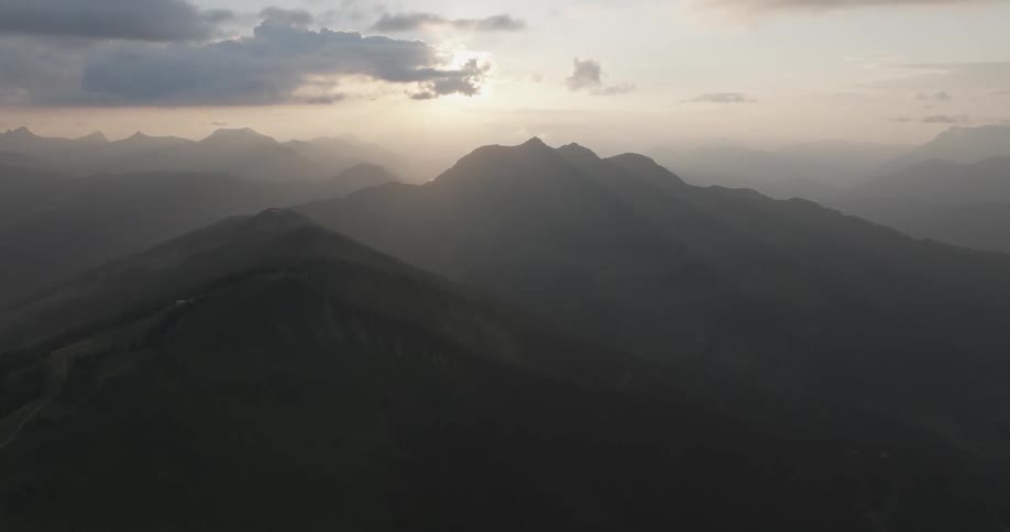 Fog covers a mountain peak with the morning sun lighting the horizon