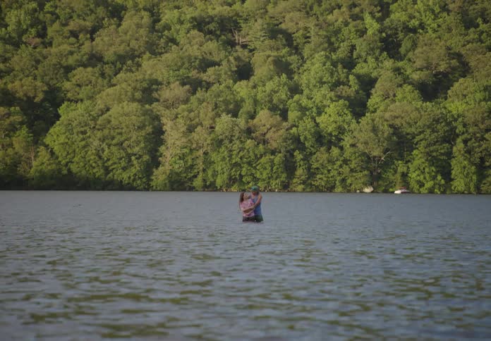 A man and woman hug in the lake