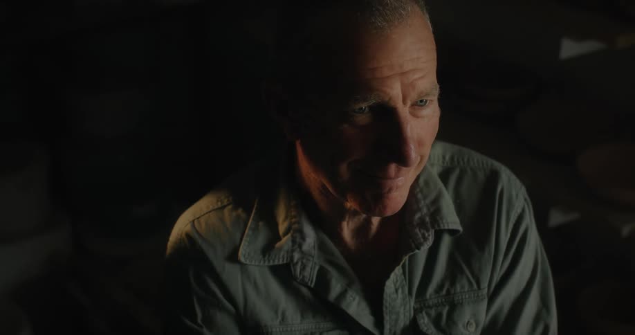 Portrait of an elderly man sitting in a dimly lit room