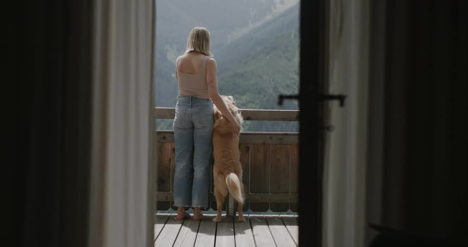 Woman enjoying the mountain landscape next to a dog