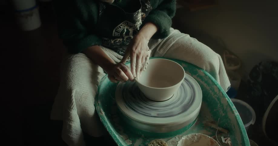 Pair of hands working on a porcelain vase