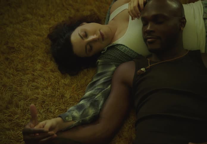 Couple holding hands lying on carpet affectionately