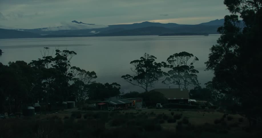 Landscape of houses on hills by a lake in the morning sky