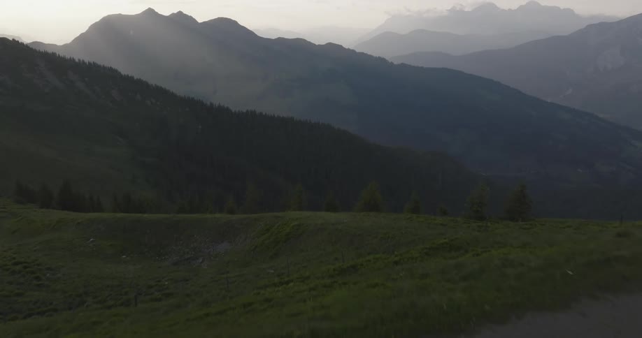 Aerial landscape of mountains in the morning and a woman walking next to a lake with her dog
