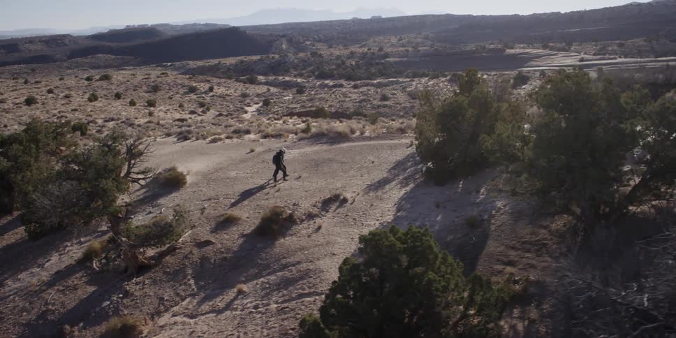 A person is hiking uphill on a mountain