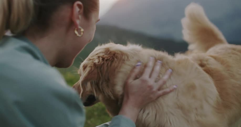 Smiling woman giving kisses and petting her dog