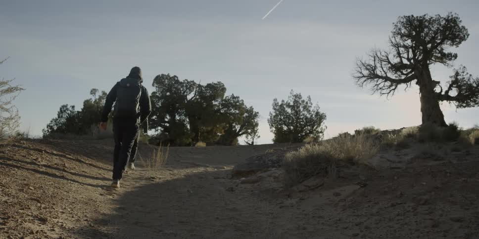 Two people are hiking up a dirt trail