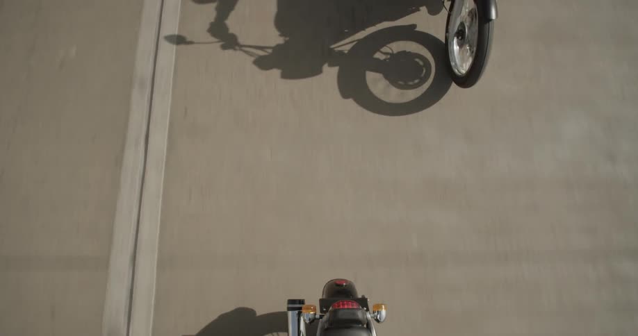 A group of motorcycles riding on a street in daylight