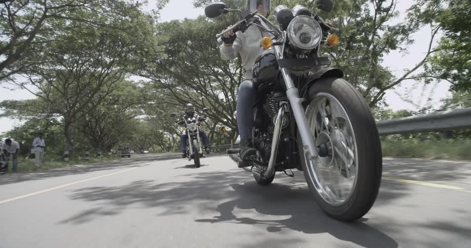 A woman and a man are riding motorcycles during the day
