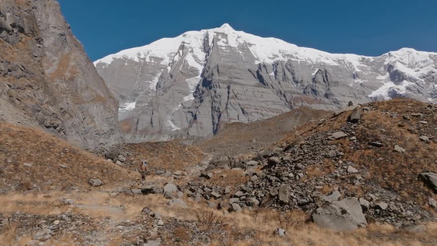 A hiker walks away from a mountain landscape