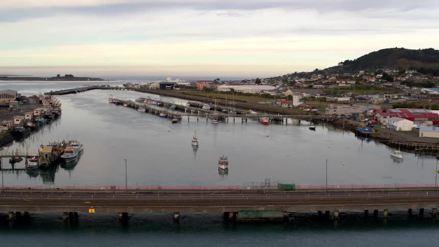 Aerial panorama of a bridge on a sea canal with an urban city in the background