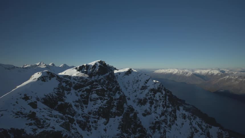 Snowcovered mountains under a dark blue sky at sunrise