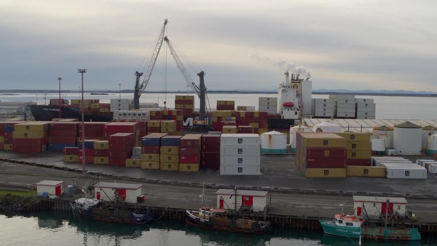 A port filled with stacked shipping containers on a coast