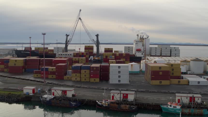 A port on a coast with shipping containers stacked up