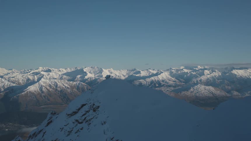 Aerial panorama of snowcovered mountain ranges against a clear blue sky